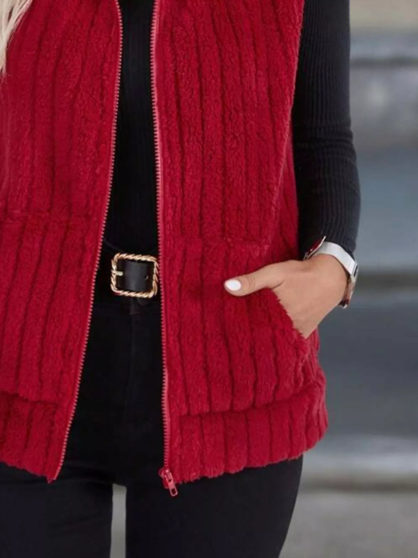 Red fleece zip-up vest with pockets and ribbed texture.