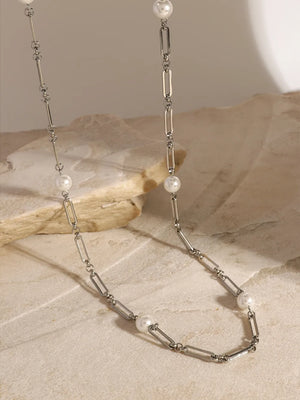 Silver two-tone pearl link necklace with elongated oval chain links and small white pearls.