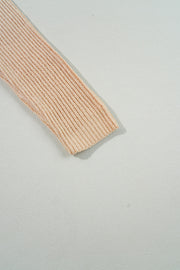Tan ribbed knit pullover sweater sleeve with asymmetric hem detail