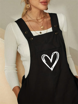 Black cotton overalls jumpsuit with a white heart pocket detail.