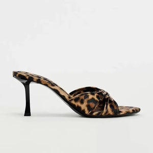 Leopard print knot heel mules with a pointed toe and stiletto heel.
