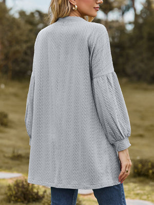 Gray textured open cardigan with balloon sleeves and a cable knit pattern.