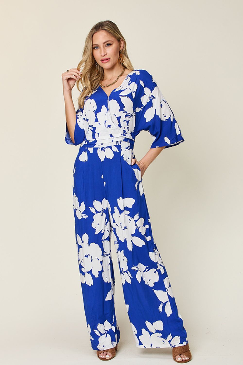 Cobalt blue floral kimono jumpsuit with wrap V-neck, wide sleeves, and wide-leg pants.
