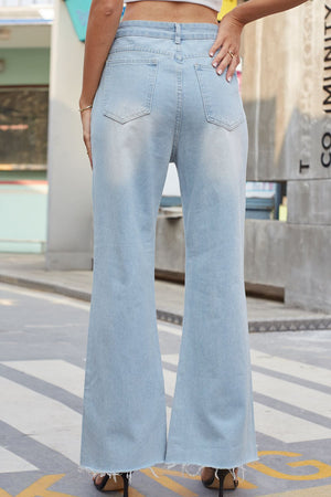 Light wash denim flare jeans with distressed knees and raw hem.