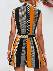 Belted romper with black, orange, and cream stripes and polka dots.