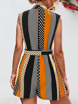 Belted romper with black, orange, and cream stripes and polka dots.