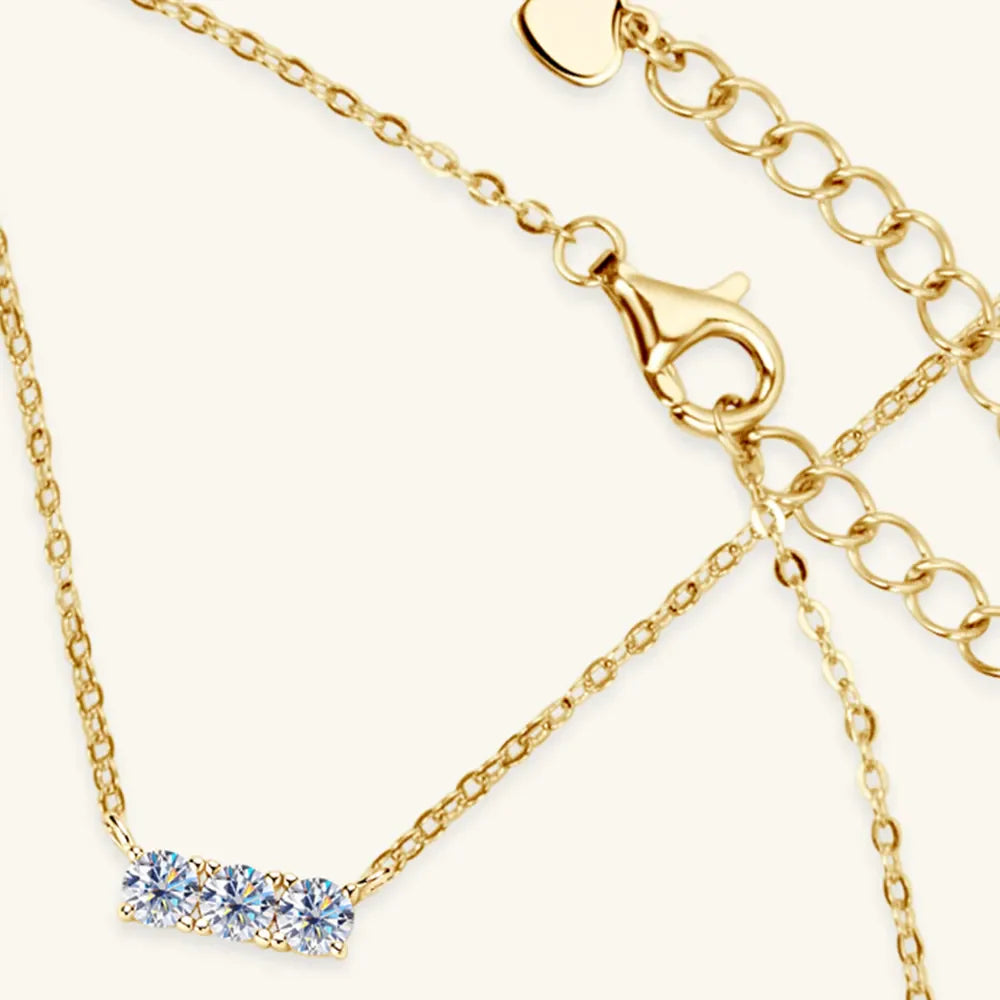 Gold bar necklace with three moissanite stones and a lobster clasp.