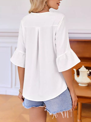 White maternity shirt with 3/4 bell sleeves and ruffled V-neck detail.