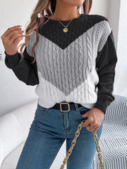 Chevron cable knit sweater with contrast black, gray, and white panels.