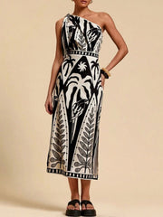 Black and white tropical print one-shoulder midi dress with defined waist and side slit.
