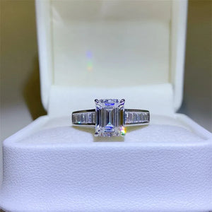 Emerald cut moissanite ring with baguette accents in silver sterling.