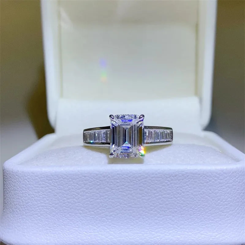 Emerald cut moissanite ring with baguette accents in silver sterling.
