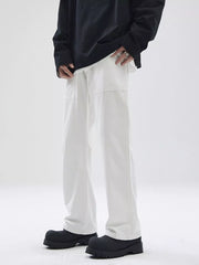 Relaxed fit white cotton chinos with patch pockets, styled with a black long sleeve shirt.