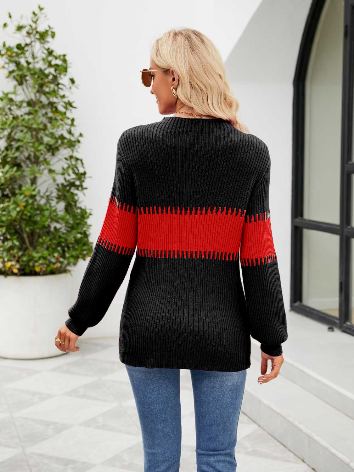 Colorblock ribbed sweater in black with red stripe detail on sleeves and torso.