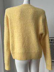 Cozy knit sweater in pastel yellow with relaxed fit and ribbed hem.