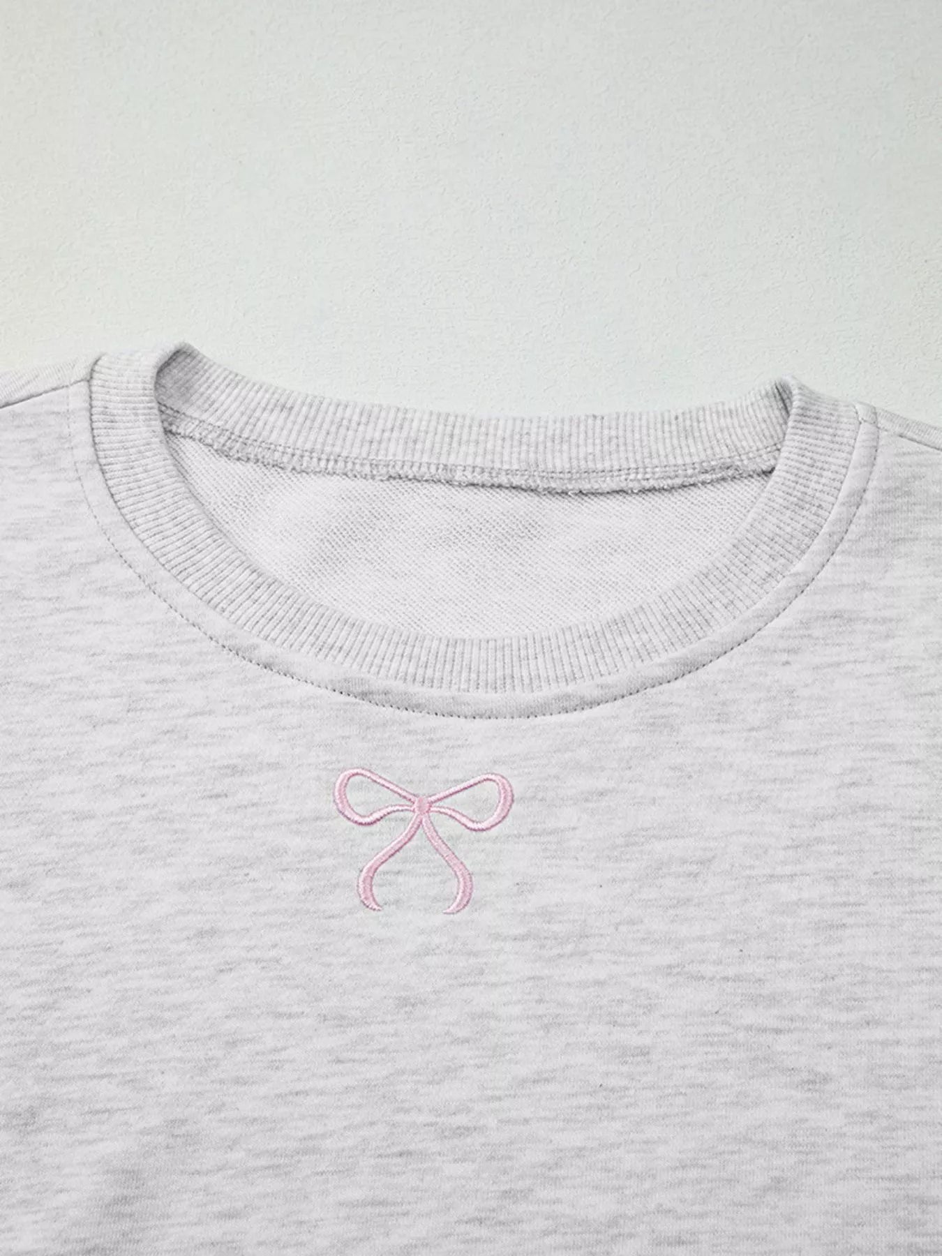 Gray crewneck sweatshirt with pink bow embroidery