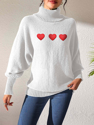 White turtleneck sweater with three red heart appliqués and balloon sleeves.