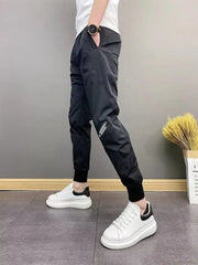 Black cotton sweatpants with ankle cuffs and subtle side leg detail.