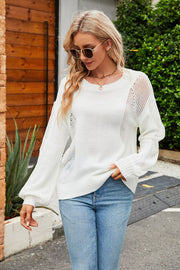 White knit sweater with slit detail on sleeves and sides, crew neck, long sleeves.