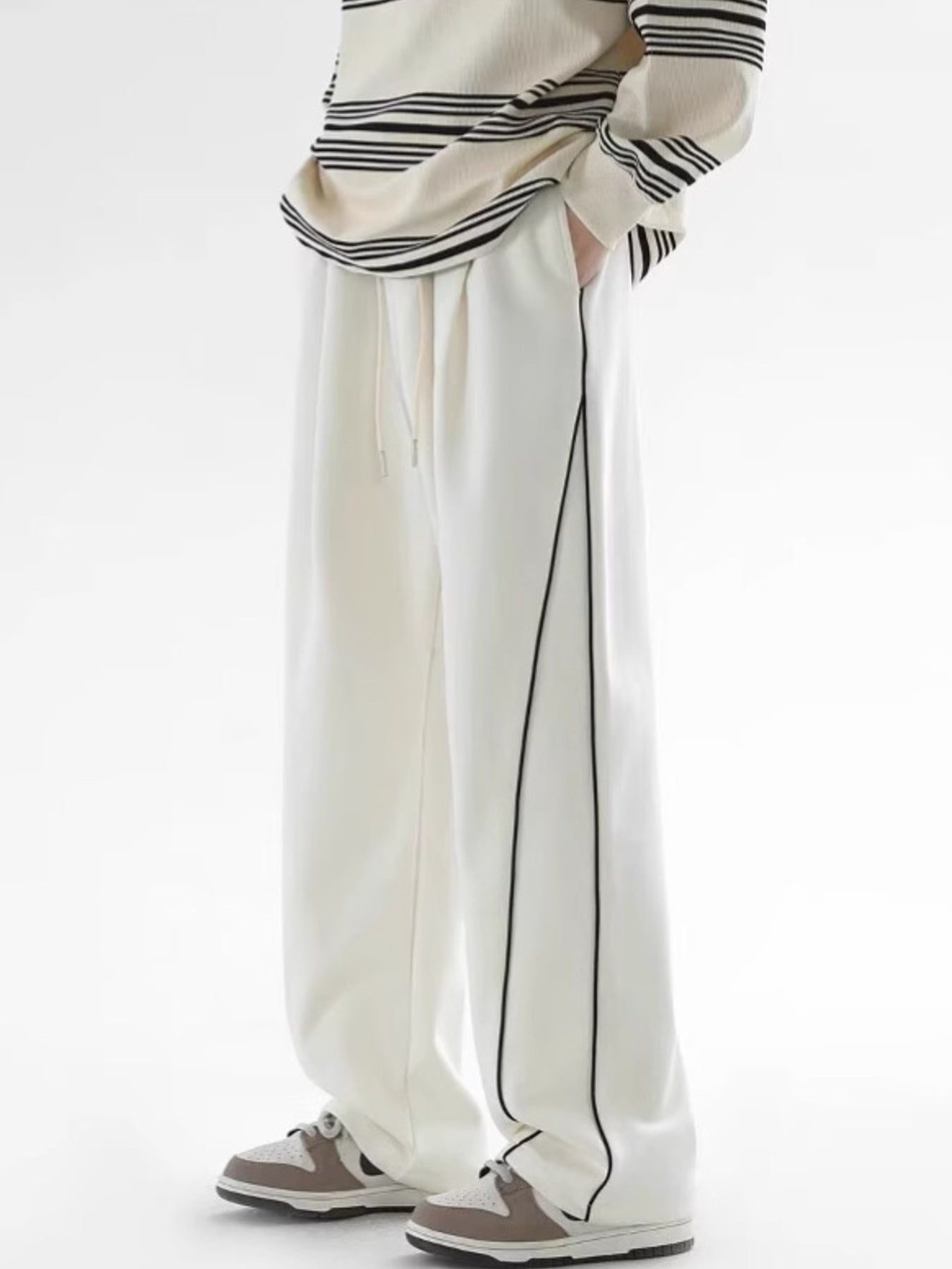 Men's white relaxed fit sweatpants with black side stripes and drawstring waist.