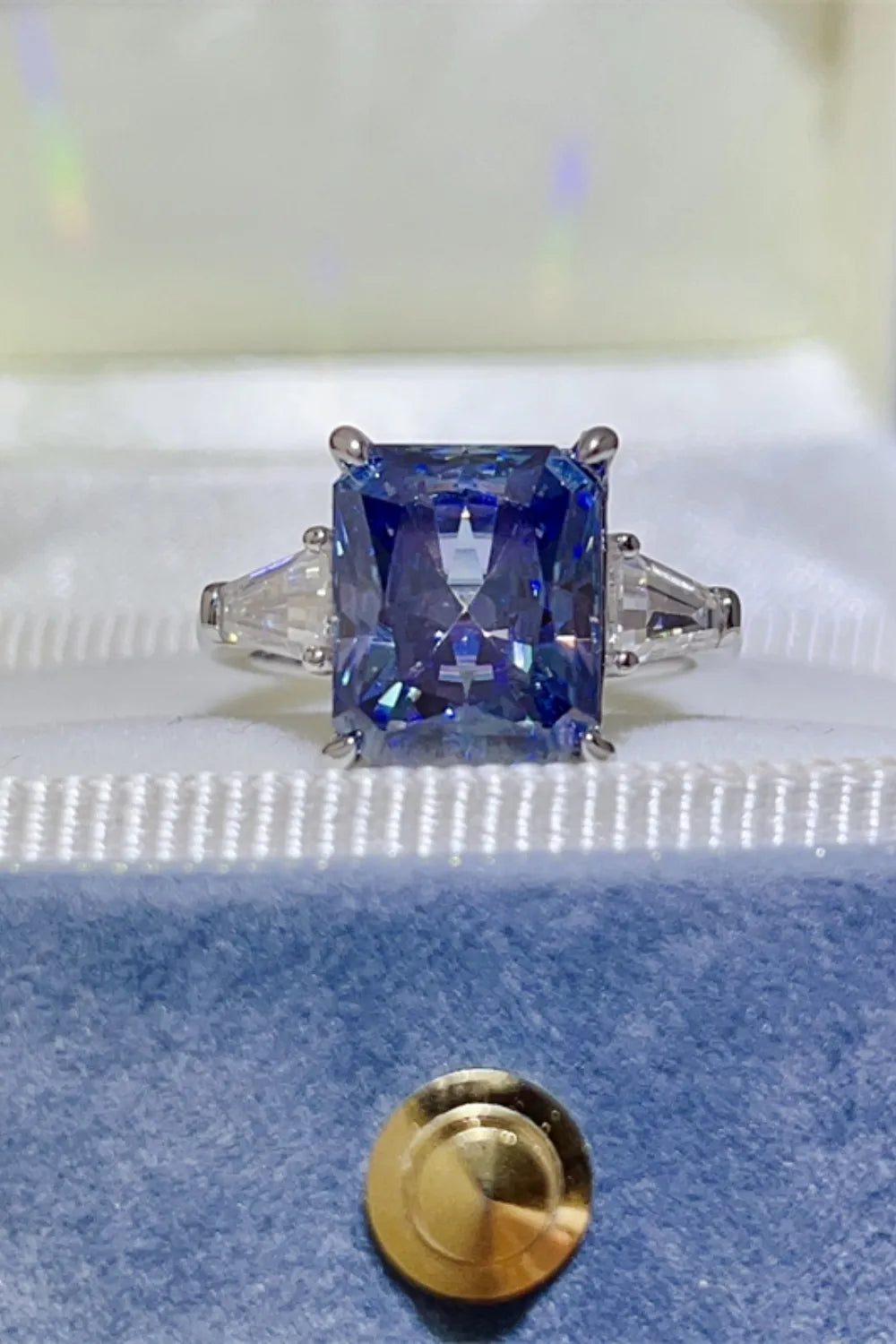 Royal blue radiant cut sapphire and moissanite ring with three stones.
