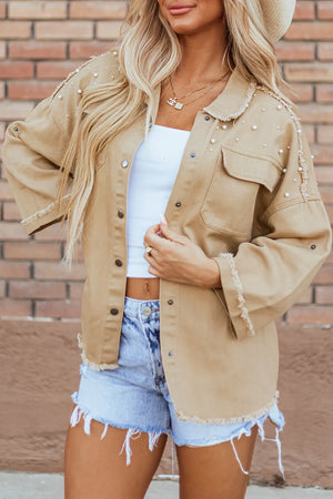 Tan cotton utility jacket with pearl embellishments and raw edges.