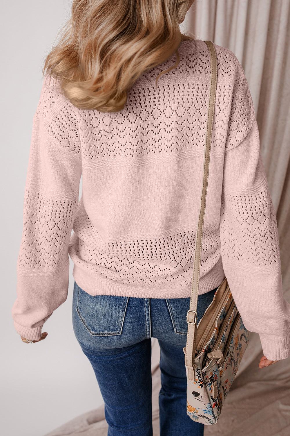 Perforated knit v-neck pullover sweater in dusty pink with allover eyelet pattern and relaxed fit.