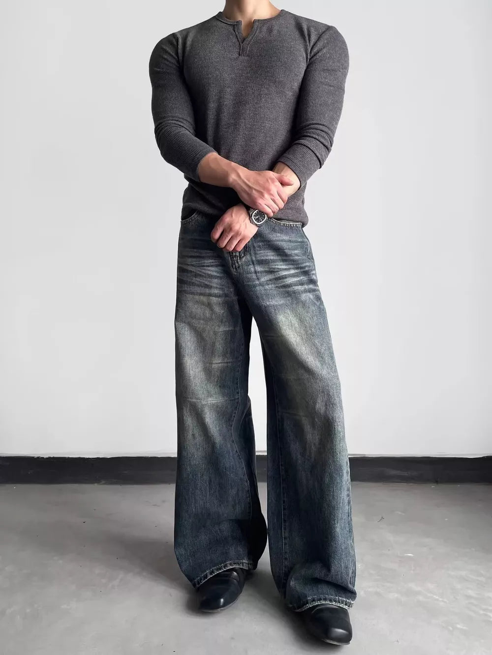 Men's blue distressed wide-leg denim jeans with a relaxed fit.