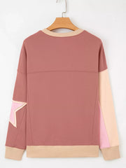 Dusty pink sweatshirt with star patchwork detail, contrast stitching, and ribbed cuffs and hem.