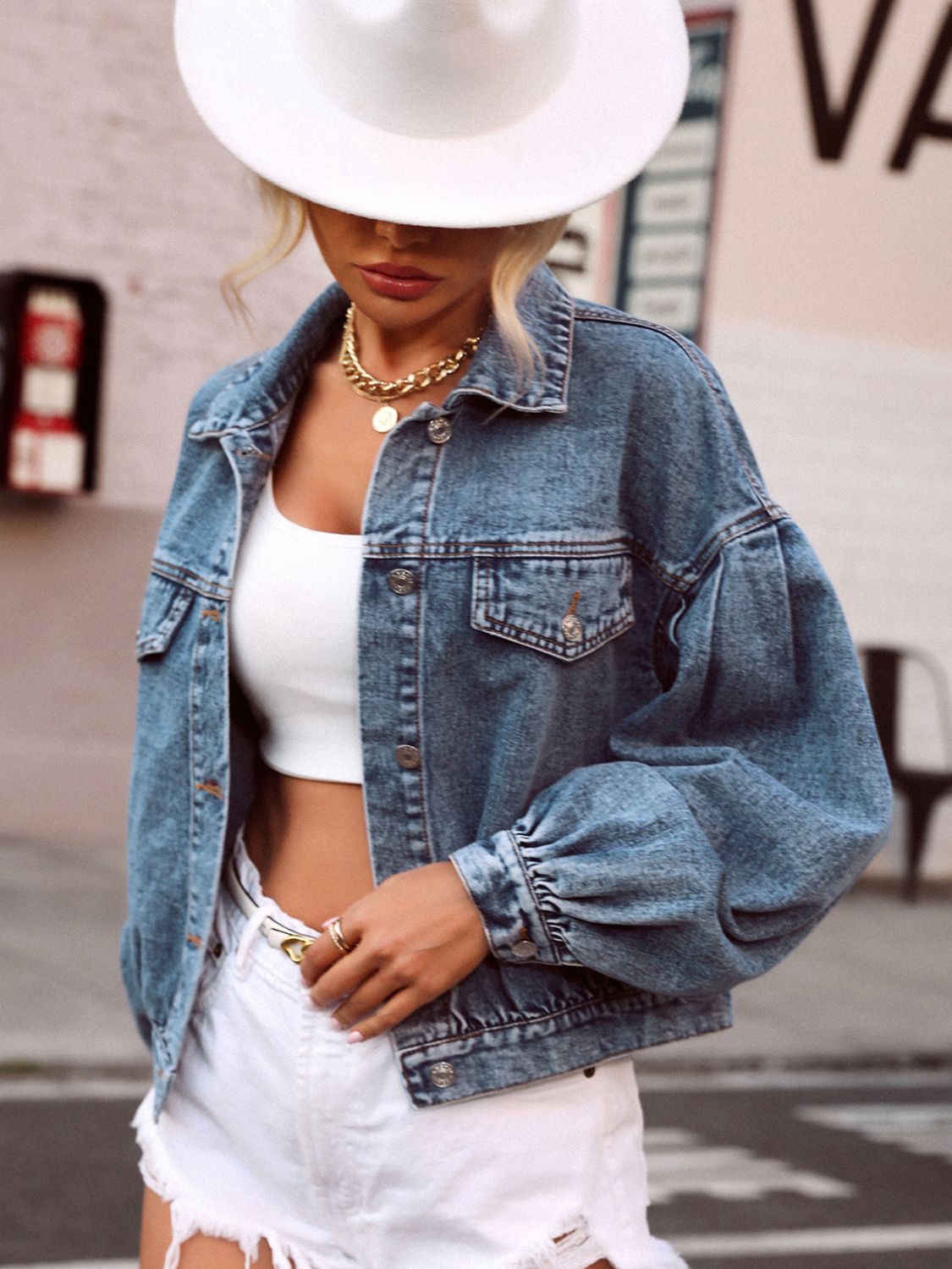 Denim cropped jacket with balloon sleeves, collared neckline, and buttoned front.