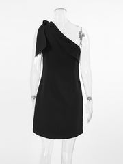 Black asymmetrical bow mini dress with one shoulder and frayed detail.
