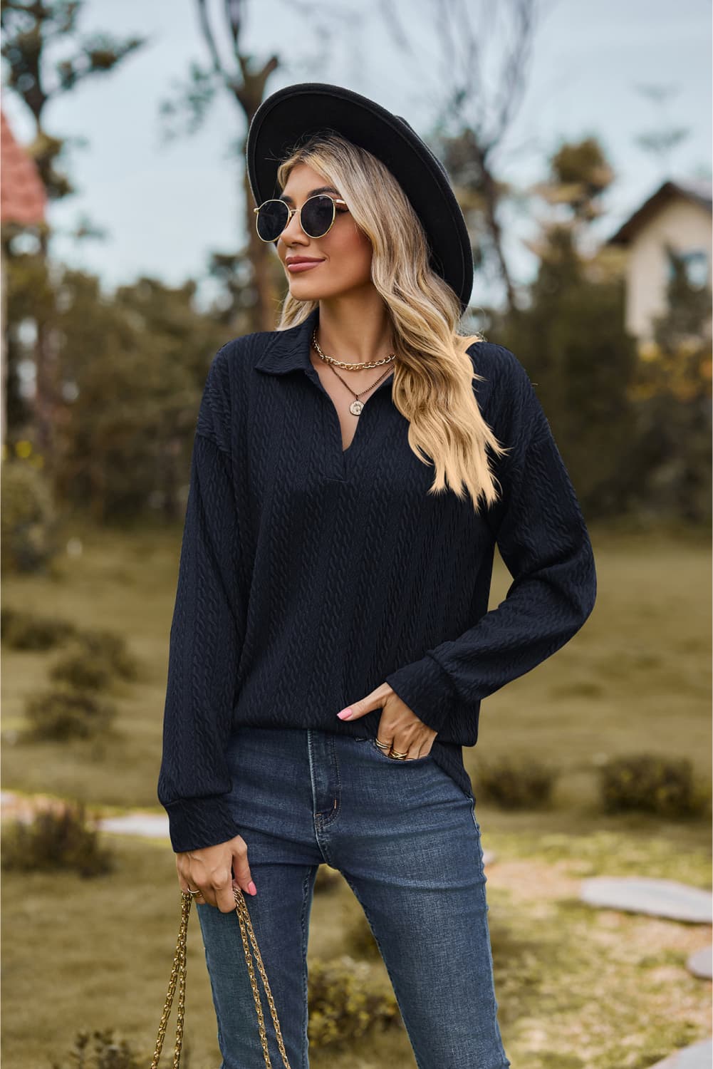 Textured cable knit polo top in dark blue with a V-neck and long sleeves.