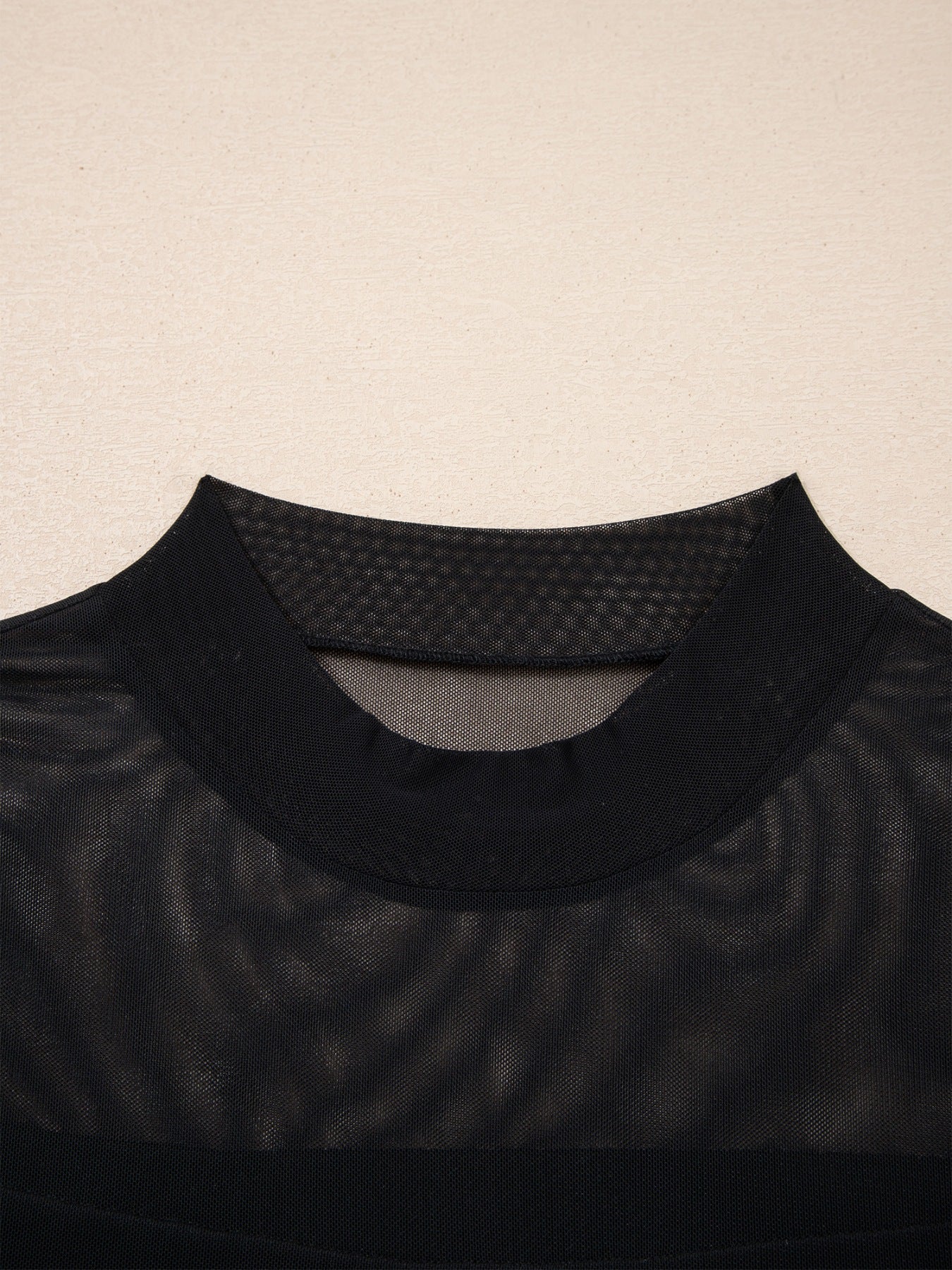 Black sheer mesh t-shirt with mock neck and cap sleeves.