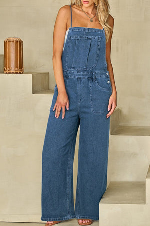 Denim wide-leg overalls in medium wash with adjustable straps and buttoned sides.