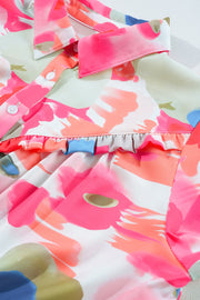 Painterly ruffle front blouse in pink with abstract floral print and button detail.