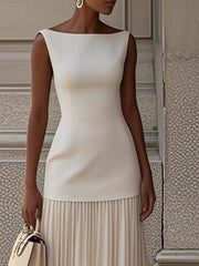 Elegant white boat neck sleeveless maxi dress with pleated skirt and gold earrings.