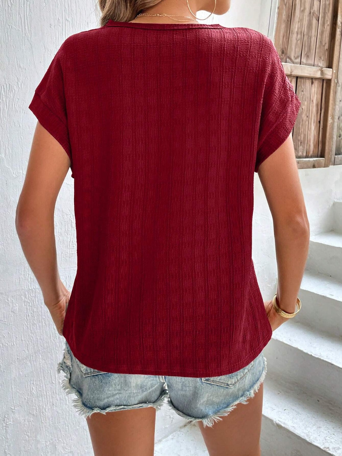 Burgundy woven texture cap-sleeve blouse with a relaxed fit.