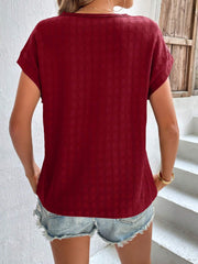 Burgundy woven texture cap-sleeve blouse with a relaxed fit.