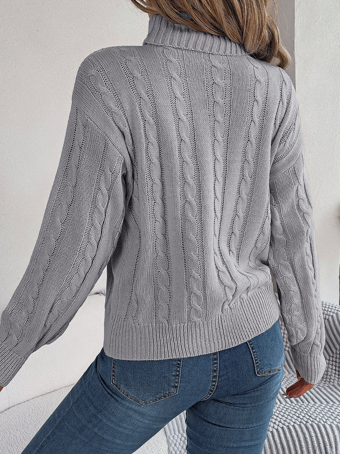 Dark Gray cable knit turtleneck sweater with voluminous sleeves and ribbed cuffs.