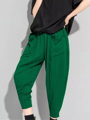 Plus size dark green harem maternity pants with vertical stripes and pockets.