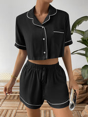 Black cropped pajama set with contrast trim, button-up shirt and drawstring shorts.