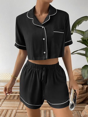 Black cropped pajama set with contrast trim, button-up shirt and drawstring shorts.