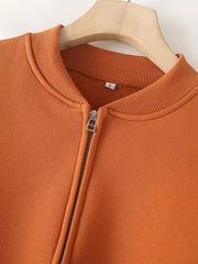 Orange zip-up casual top with ribbed collar and cuffs