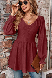 Burgundy textured blouse with V-neck, empire waist, and shirred long sleeves.