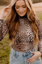 Sheer leopard print turtleneck top with long sleeves.