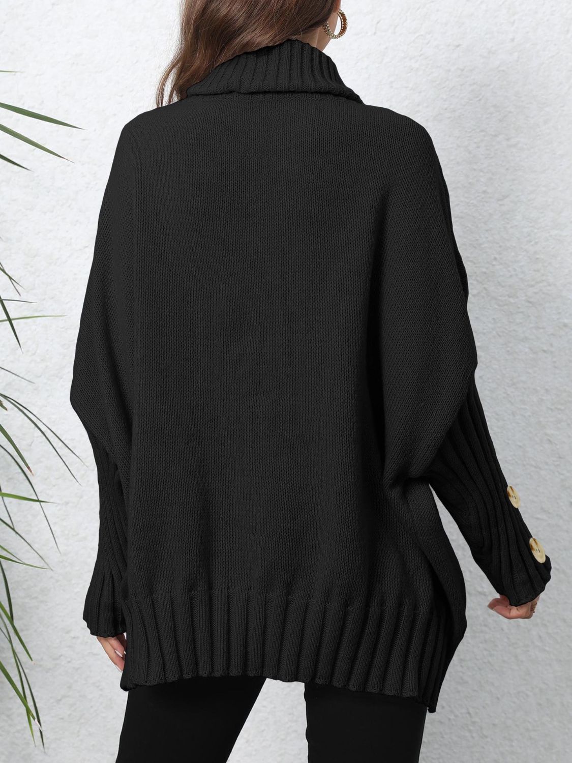Black turtleneck sweater with button cuffs and slouchy knit sleeves.