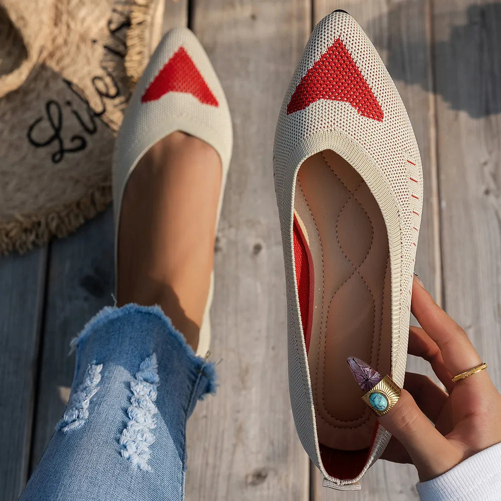 Beige knit pointed flats with red geometric pattern detail and red trim.