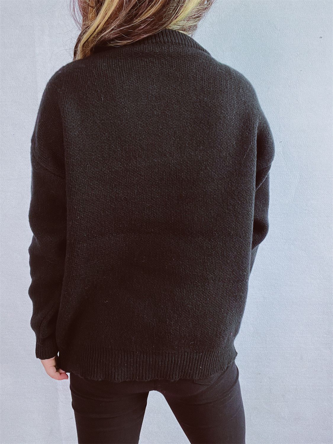 Black acrylic knit sweater with crew neck and ribbed cuffs and hem.