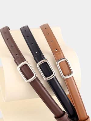 Leather skinny belts in brown, black, and caramel with silver buckle detail.