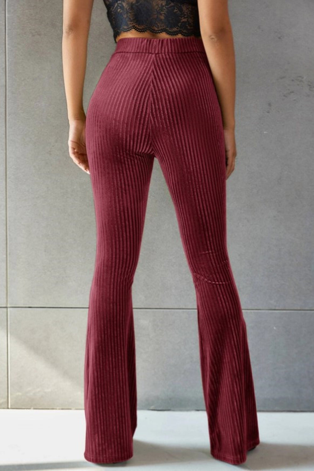Burgundy ribbed velvet palazzo trousers with a flared leg.